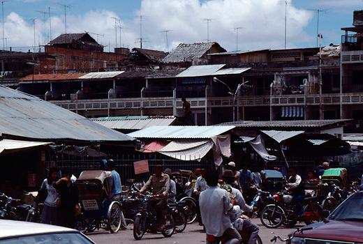 Mitten in Phnom Penh sieht man auf Terrassen und Dächern der Stahlbetonskelettbauten palmblattgedeckte Hütten der ländlichen Bevölkerung.