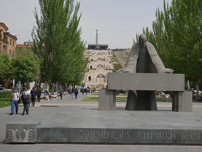 Die Kaskade, Jerewans Treppenkomplex, und das oberhalb davon gelegene 'Russisch-Armenische Monument des 50. Geburtstages' sind hier im Hintergrund zu sehen. Im Vordergrund: Die Alexander-Tamanyan-Statue