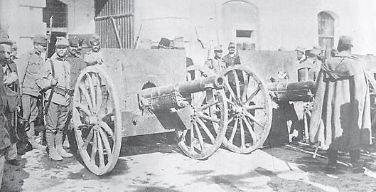 Österreichische Soldaten stehen neben erbeuteten serbischen Kanonen