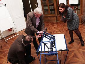 Burghard Kaltenbeck (Mitte) startet mit der Code-Karte die Maschine von Künstler Niki Passath. – (Foto: Martin Krusche)