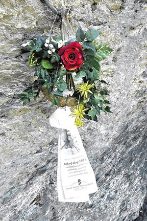 Eine Bronzeplakette und ein Plastikblumenkranz mit Parte erinnern an das vermeintliche Ende des Meisterdetektivs am Reichenbachfall