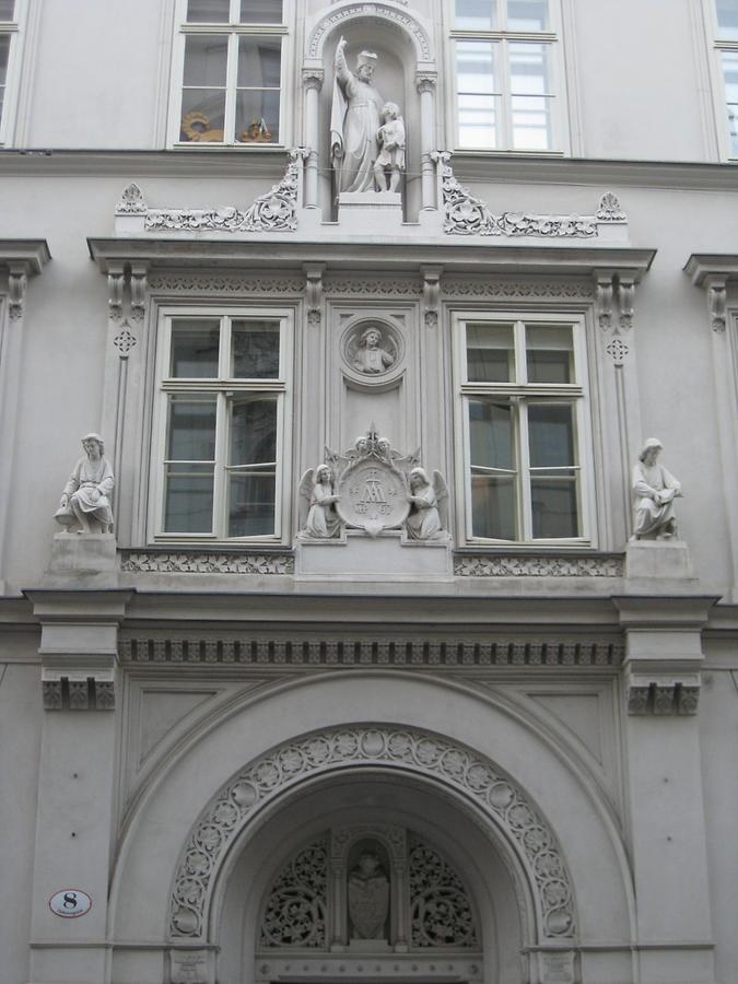 Portal mit Hl. Joseph Calasanz-Statue, dem Wappen'Maria Treu' und lesenden Knaben