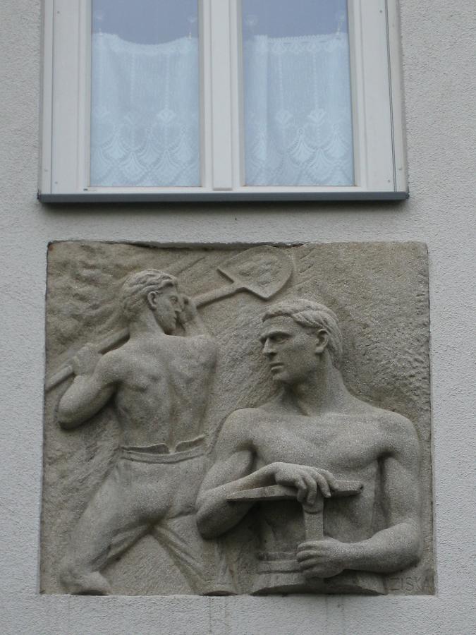 Hauszeichen als Kunststeinrelief 'Erdarbeiter' von Elisabeth Ziska 1952