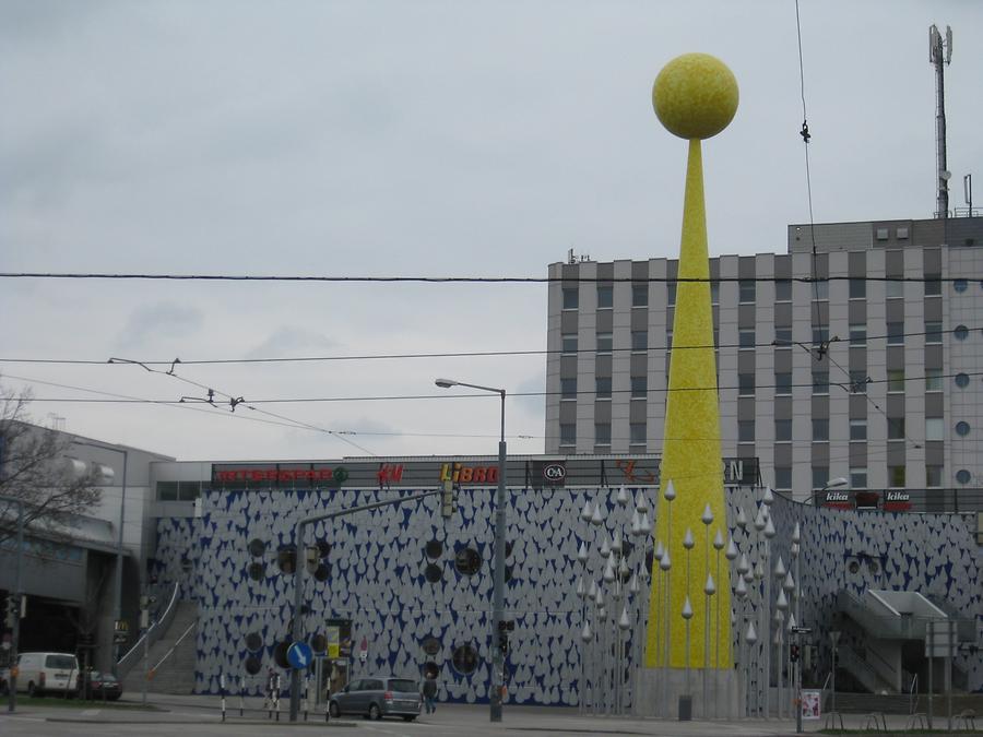 Skulptur 'Sonnenstrahl' vor den Regentropfen des Donauzentrum-Südteil-Außenwand