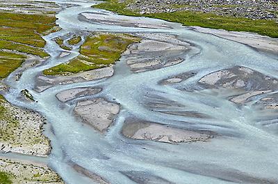 Wasser fließt breit am Talboden