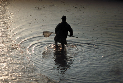 Silhouette eines Fischers mit Fischernetz, © IMAGNO/Gerhard Trumler