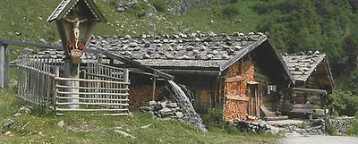 Die Heiligen Georg und Katharina sowie ein Marien-Medaillon zieren die Front des Almhauses auf der Wager-Alm.