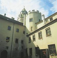 Der gotische, vielfach umgebaute Innenhof der Haller Stadtburg Hasegg (hier mit dem Bergfried im Hintergrund) beeindruckt durch seine vielfältige Treppen-. Tür- und Fensterformen sowie seine Bögen und Erker.