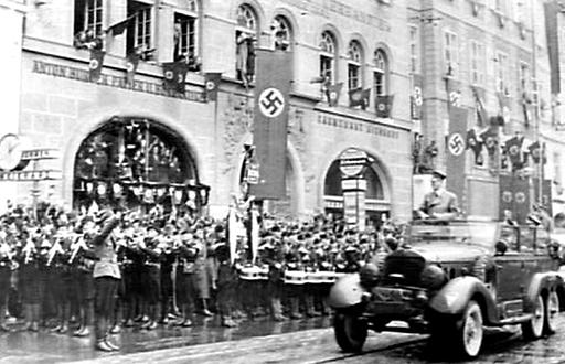 Hitler fährt im Konvoi durch die Herrengasse auf den Grazer Hauptplatz. Links die Weikhard-Uhr