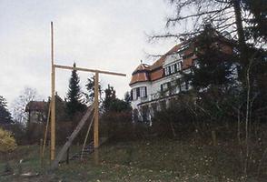 Hier wird bei einer Villa mit grossem zugehörigem Park mit einem Lattengerüst demonstriert, wie hoch der geplante Neubau im Park werden soll.