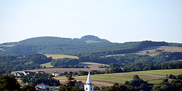 Sieggrabener Kogel (bewaldete Berg­kuppe), im Vordergrund der Turm der römisch-katholischen Pfarrkirche Kobersdorf