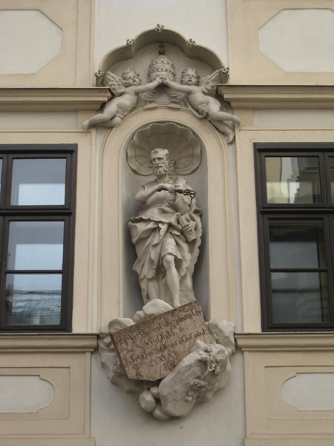 Steinstatue des Hl. Petrus bekrönt von thiarahaltenden Putti