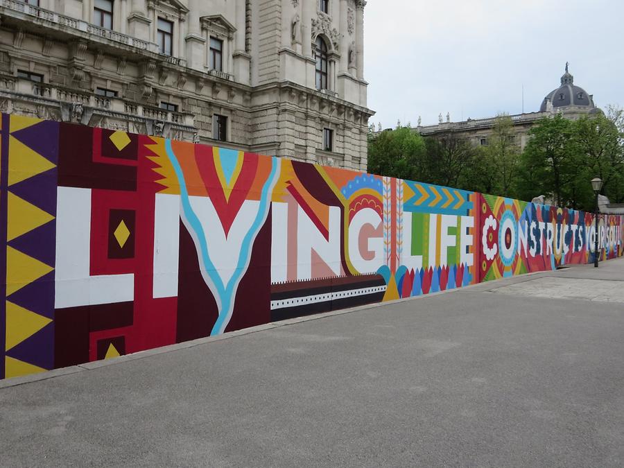 Weltmuseum-Bauzaun Street Art Graffito 'Living Life Constructs Your Soul' von Boa Mistura 2017
