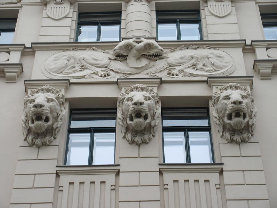 Drachen- und Löwenköpfe-Fassadenreliefs