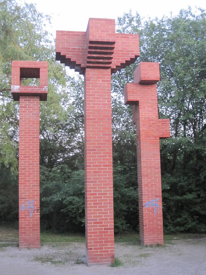 Skulptur 'Drei Stelen mit verschiedenen Kopfteilen' von Manfred Wakolbinger 1989