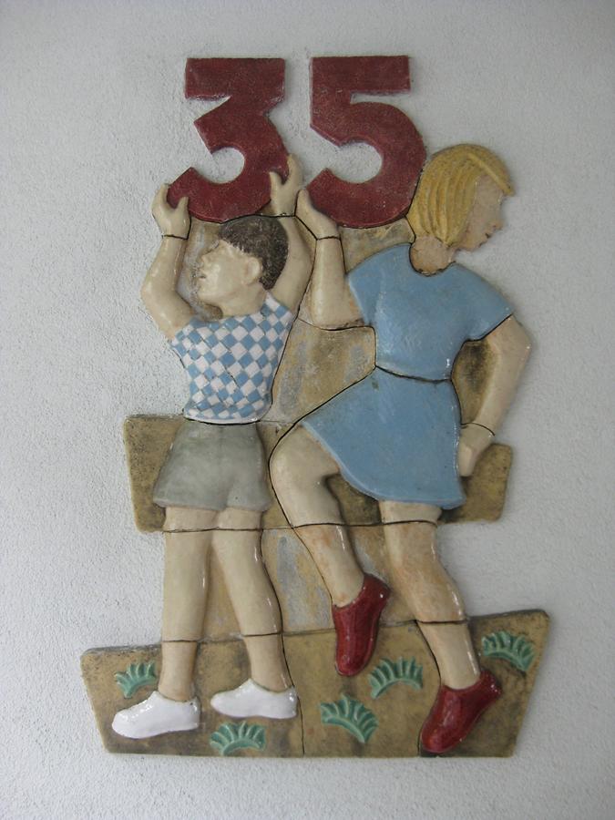 Keramikrelief-Hauszeichen 'Knabe und Mädchen mit Ziffer 35' von Hans Rauser 1952
