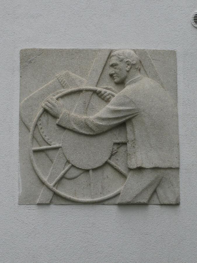 Hauszeichen als Kunststeinrelief 'Betonmischer' von Anton Endstorfer 1952