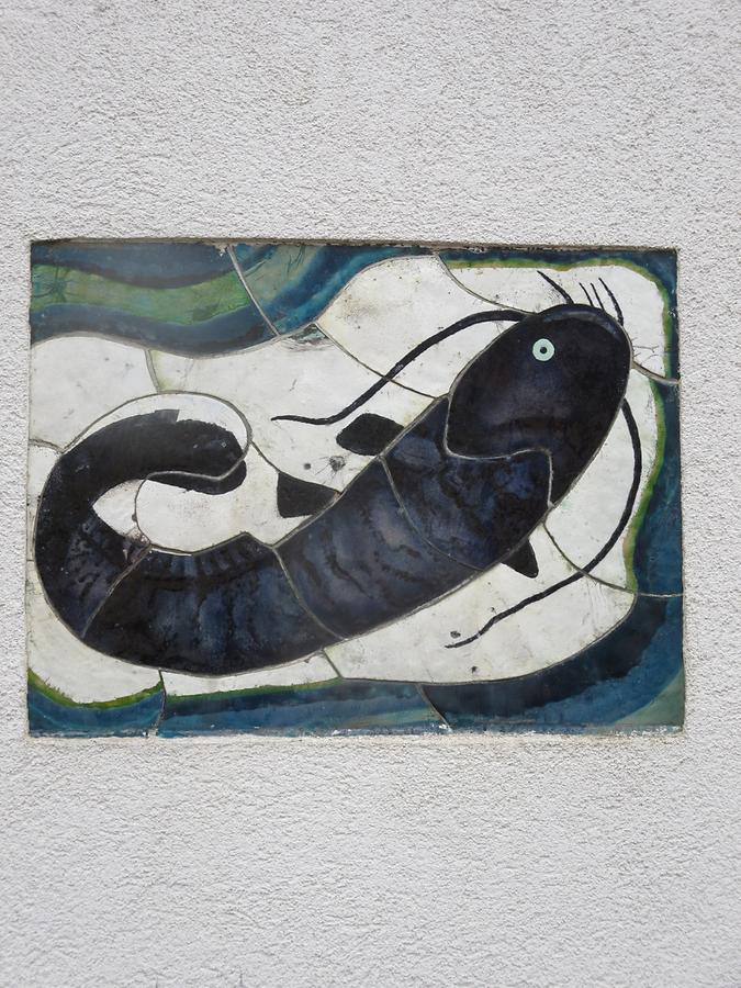 Kachelmosaik-Hauszeichen 'Wels' von Maria Schwammberger-Riemer 1955 Kachelmosaik-Hauszeichen 'Wels' von Maria Schwammberger-Riemer 1955