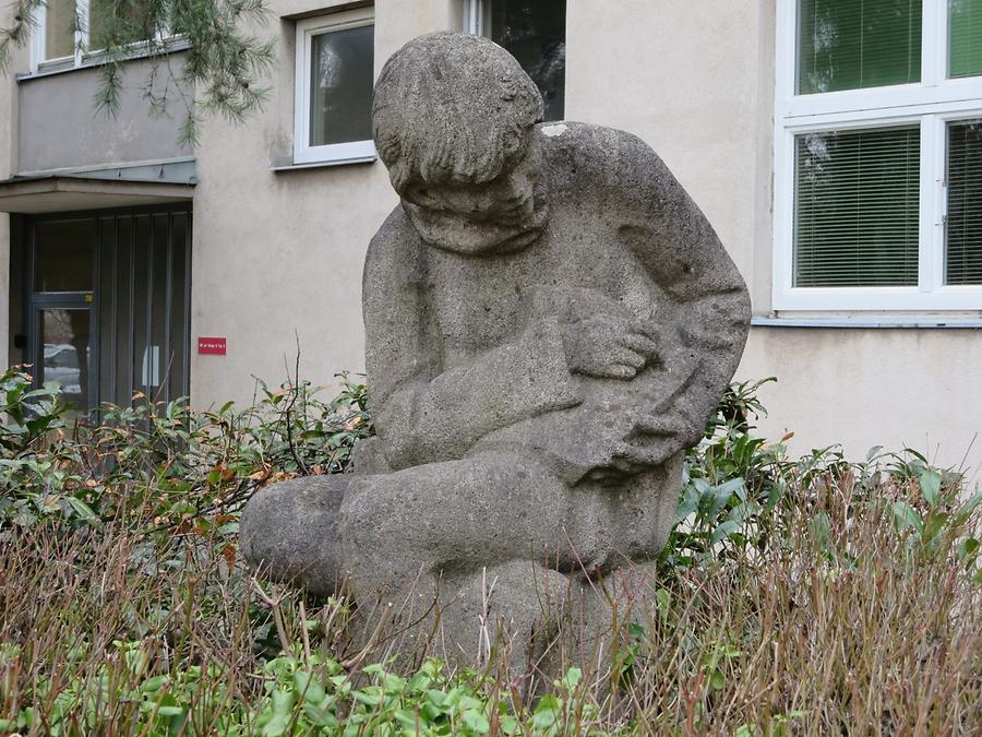 Natursteinplastik 'Schreibender Bub' von Margarete Hanusch 1965