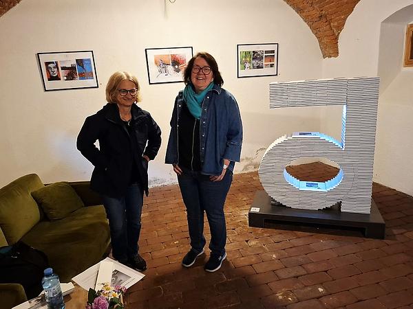 Christa Zmölnig (links) und Martina Brandl neben der Skulptur von Tanja Alber, vor dem Set von Kier Fox.