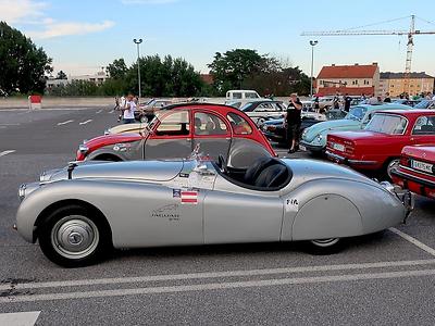 Volkskultur in der technsichen Welt: Jaguar XK 140 vor Ente.