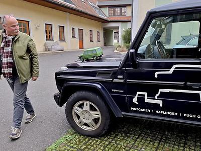 Wunderbare Exponate: (Ohne famose Leihgeber wär es nur das halbe Vergnügen). Auftritt Markus Rudolf auf dem Gleisdorfer Florianiplatz. Zum Thema passend im eher seltenen V8 Diesel. Was er mitbringt, kann man nirgends kaufen. Es sind einige Originale aus den alten Puchwerken. Ein stattliches Holzmodell des Puch G, noch ohne dem „Spekner-Bürzel“ in der Dachlinie. Eine Metallmodell aus der damaligen Lehrwerkstatt. Dazu Sondereditionen von Modellen in kleinen Auflagen und Medaillen aus dem Besitz seines Vaters Egon Rudolf, dem letzten Werksdirektor der historischen Puchwerke.