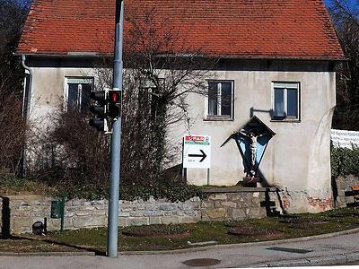 GLD025: Die Tafel macht deutlich, daß es inzwischen auch denkbar wäre, Jesus ein Leiberl mit Sponsor-Aufdruck zu verpassen.