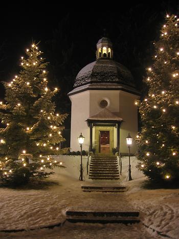 Stille-Nacht-Kapelle, wohl am Weihnachtsabend, beleuchtete Christbäume - Foto: Gakuro, Wikimedia Commons - Gemeinfrei