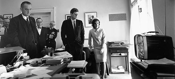 In der Mitte US-Präsident Kennedy, seitlich seine Ehefrau Jacqueline und links Vizepräsident Lyndon B. Johnson sowie Mitarbeiter. Sie beobachten mittels TV den Flug von Astronaut Alan Shepard, 5. Mai 1961