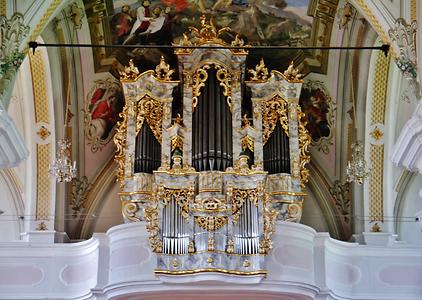 Orgel der Basilika St. Michael von Absam, Tirol - Foto: Zairon (05. Juni 2015, 11:18:37), Wikimedia Commons - Gemeinfrei. - Die Orgel wurde 1776 von dem Orgelbauer Johann Anton Fuchs (1737-1796) erbaut. Er gehörte einer österreichischen Orgelbauerfamilie an, deren Mitglieder in drei Generationen in Tirol als Orgelbauer tätig waren. Unter Aufsicht des Bundesdenkmalamtes wurde das Instrument erstmals 1948 restauriert. Eine Überholung erfolgte 2002 durch den österreichischen Orgelbauer Christian Erler (Werkstätte in Schlitters/Zillertal) sowie Intonierung (Orgelklang) vom Orgelbauer Vier. Es besitzt 23 Register auf zwei Manualen und Pedal. Die Kirche wurde im Barock erneuert und u. a. im Rokokostil gehalten, so auch der interessante Orgelkasten