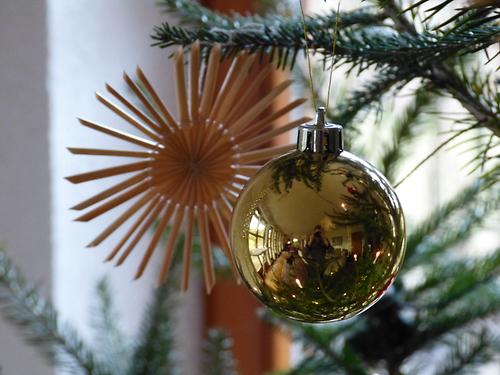 Strohstern und Kugel als Dekoration am Christbaum