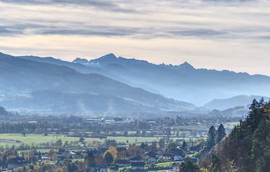 Teleblick über Wörschach, Steinach und Schloss Trautenfels hinweg zu den Schladminger Tauern: der markant spitze Höchstein, sowie links der massige Gipfelaufbau der Hochwildstelle, dem höchsten innersteirischen Berg