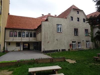 Die Südseite des Hauses lässt mehrere Bauphasen des Komplexes erkennen. Der geräumige Garten wird inzwischen für den Kindergarten mitgenutzt.