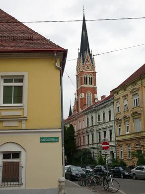 Dieses Foto zeigt die Nähe zum Turm der Herz-Jesu-Kirche. Diesem einzigartigen Sakralbau sollte mit dem Neubauprojekt ursprünglich ein 12 Geschosse hoher sehr breit angelegter Turm ohne jede architektonische Qualität entgegengesetzt werden