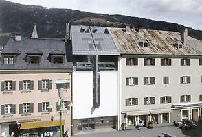 Abb.1 - Straßenseitige Hauptfassade von Raimund Abraham`s HYPO-Bank in Lienz in Osttirol aus dem Jahr 1993. Die Dachneigung orientiert sich am Dach des rechten Nachbarobjektes, verarbeitet aber auch jene des links anschlie-ßenden Gebäudes. Obwohl die Gestaltung in Ihrer Großflächigkeit nur asketisch Bezüge zur Nachbarschaft herstellt, wird hier die Symmetrie zu einem integralen Gestaltungsmerkmal., Foto: A. Scheucher