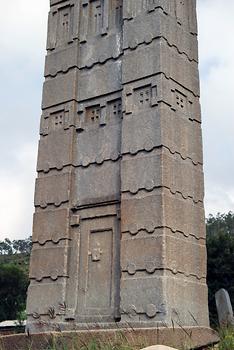 Grabstele 3 von Axum; die Tür zeigt hier ein aus dem Stein modelliertes traditionelles Holzfallenschloss mit Riegel. Die Stele ist ca. 23,5 m hoch (mit geschätztem Fundament) und ist seit ihrer Aufstellung vor fast 2000 Jahren nicht umgestürzt.
