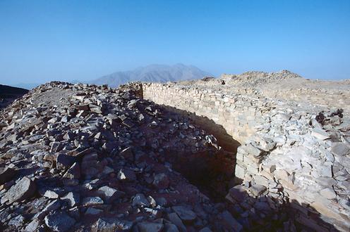 Eines der zweifach abgewinkelten Tore durch die innere Wehrmauer. Im Hintergrund der Vulkan Cerro Mucho Malo.