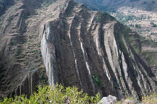 Auf den Felsformationen auf der gegenüberliegenden, nördlichen Seite des Taulliragra-Tales erkennt man einen Fußweg.