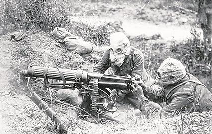 Zwei britische Soldaten mit Gasmasken bedienen ein MG