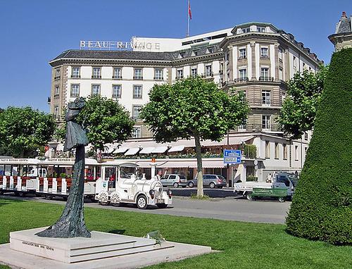 Das Hotel Beau Rivage, im Vordergrund eine Statue von Kaiserin Elisabeth.