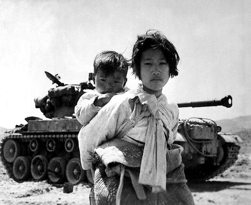 Viele Zivilisten waren vom Krieg betroffen: Mädchen mit Bruder am Rücken auf der Flucht, Südkorea. Juni 1951.