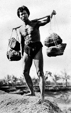 Tragen: Balinesischer Steinträger mit einem Tragejoch; vor 1943 (Foto: Unbekannt, Quelle: Tropenmuseum Amsterdam, Creative Commons)