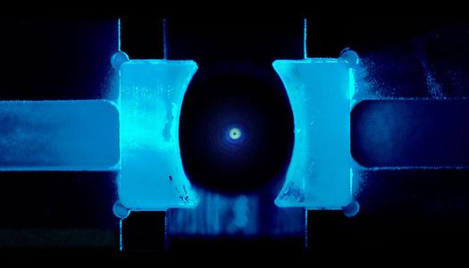 Forscher kühlten zum ersten Mal ein schwebendes Nanoteilchen in den Quantengrundzustand. Diese Arbeit wurde durch die kürzlich bahnbrechende Anwendung der kohärenten Streuung auf dem Gebiet der Hohlraum-Optik ermöglicht.