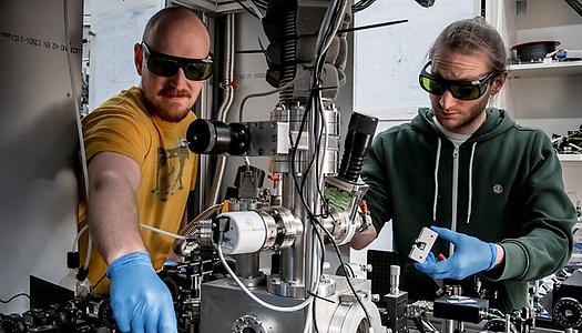 Wissenschafter aus Wien, Kahan Dare (links) und Manuel Reisenbauer (rechts), am Experiment, das ein schwebendes Nanoteilchen in seinen bewegten Quantengrundzustand kühlte