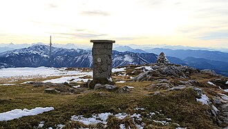 Blick vom Gipfel mit Festpunkt für die trigonometrische Vermessung und Gipfelkreuz Richtung Süden.
