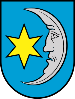 StadtMattighofenIn Blau eine silberne, rechtsgekehrte Mondsichel, in der Höhlung begleitet von einem goldenen, sechsstrahligen Stern.