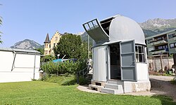 Eine graue Kuppel zur Sternenbeobachtung steht auf grünem Rasen im Botanischen Garten. Die Türen und Luken sind geöffnet.