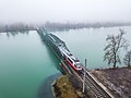Der erste Personenzug, nach der Elektrifizierung, bei der Überfahrt über die Eisenbahnbrücke.
