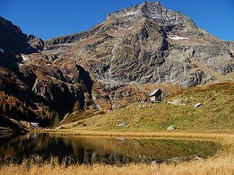 Ostseite. Hochgolling mittig (2862 m), links Tramörtenscharte (2442 m) und rechts Rottor (rund 2270 m). Im Vordergrund der Gralatisee (rund 1810 m).