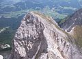 Kaiserkopf von Norden mit Nordgrat, davor die Rote-Rinn-Scharte, hinten rechts der Hirschanger (grasiger Sattel) mit Übergang zum Treffauer, im Tal links Going am Wilden Kaiser, rechts Ellmau